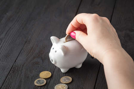 Save money concept, Piggy bank in a human hand with coinの写真素材