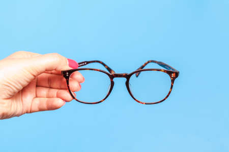 Female hand holding Eye Glassesの写真素材