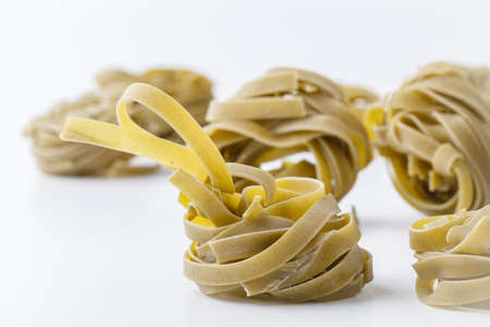 italian spinach tagliatelle nests on whiteの写真素材