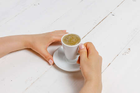 A woman's hand holding an espresso cupの写真素材