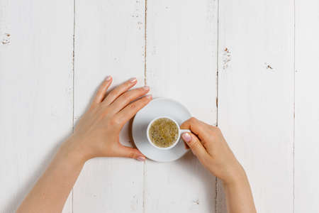 High angle of female hands hold a cup of strong coffeeの写真素材