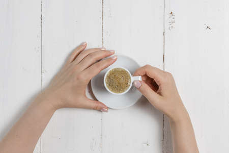 A woman's hand holding an espresso cupの写真素材
