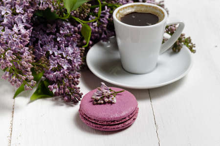 Little delicate elegant bouquet of spring flowers and a teacup on white wooden table, morning breakfastの写真素材