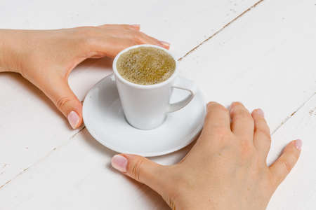 High angle of female hands hold a cup of strong coffeeの写真素材