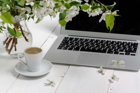 Feminine workplace concept. Freelance fashion comfortable femininity workspace  with laptop, coffee, flowers on white backgroundの写真素材