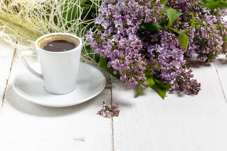 Coffee cup and colorful lilac flowers on garden tableの写真素材