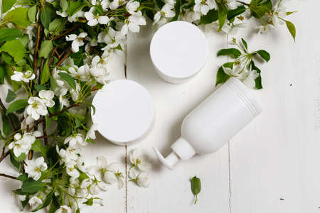 Body care cosmetics white bottle with flowers flat layの写真素材
