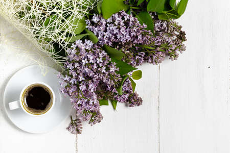 Coffee cup and colorful lilac flowers on garden tableの写真素材
