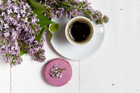 Coffee cup and colorful lilac flowers on garden tableの写真素材