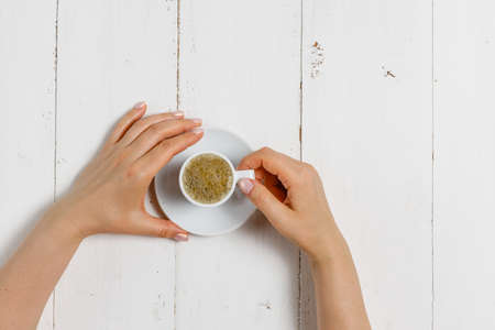 High angle of female hands hold a cup of strong coffeeの写真素材