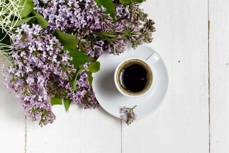 Coffee cup and colorful lilac flowers on garden tableの写真素材