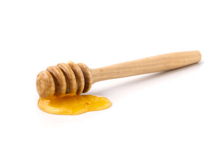 Wooden honey dipper with honey isolated on whiteの写真素材