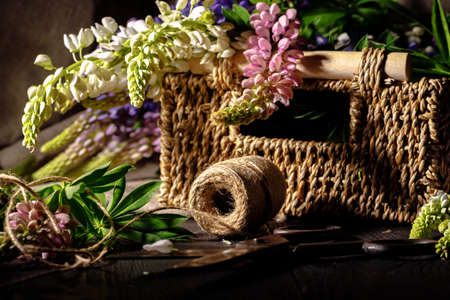 Fresh flowers, leaves, and tools to create a bouquet on a table, florist's workplaceの写真素材