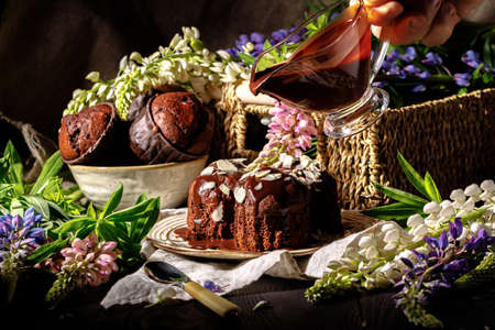 Chocolate muffins with chocolate syrup on dark background, selective focusの写真素材