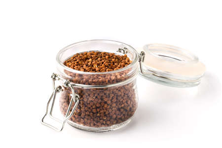 bunch of buckwheat in jar, close up on a white background. Isolatedの写真素材