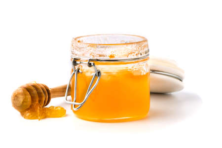 honey dipper and honey in jar on white backgroundの写真素材