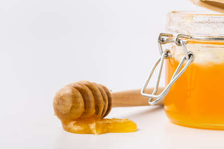Wooden dipper with jar of honeyの写真素材