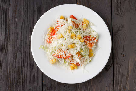 Fresh salad in wooden plate on wood tableの写真素材