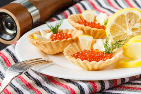 Tartlets with red caviar on a plate. Selective focusの写真素材