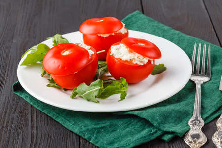 tomatoes stuffed with spinach, cheese and herbs, close up. Delicious and nutritious vegetarian mealの写真素材