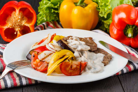 Grilled meat steak with vegetables in a plateの写真素材