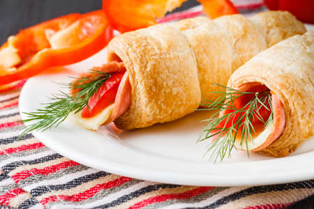 Fresh croissant with ham and salad leaf on dark wooden backgroundの写真素材