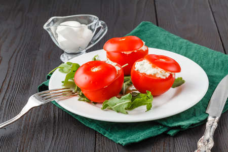 tomatoes stuffed with spinach, cheese and herbs, close up. Delicious and nutritious vegetarian mealの写真素材