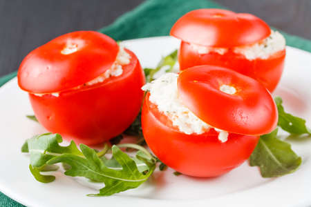 tomatoes stuffed with spinach, cheese and herbs, close up. Delicious and nutritious vegetarian mealの写真素材