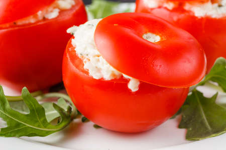 tomatoes stuffed with spinach, cheese and herbs, close up. Delicious and nutritious vegetarian mealの写真素材