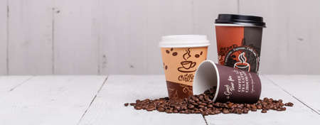 Paper cups of coffee on wooden texture backgroundの写真素材