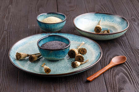 Poppy seeds and seedpods in ceramic bowlの写真素材
