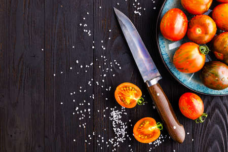 Fresh tomatoes in a plate on a dark background. Harvesting tomatoes. Copy spaceの写真素材