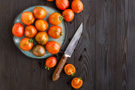 Fresh tomatoes in a plate on a dark background. Harvesting tomatoes. Copy spaceの写真素材
