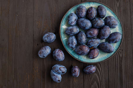 fresh ripe Plums in dish on tableの写真素材