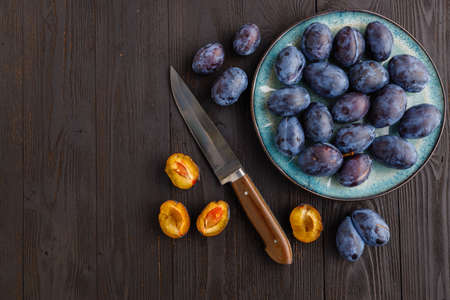 fresh ripe Plums in dish on tableの写真素材