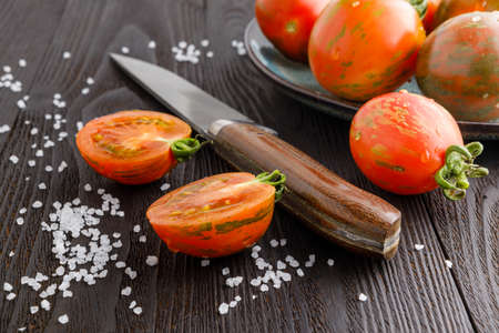 Fresh tomatoes in a plate on a dark background. Harvesting tomatoes. Copy spaceの写真素材