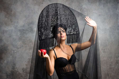 Amazed woman at russian traditional cap hat kokoshnik holding red appleの写真素材