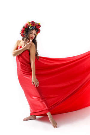 Beautiful romantic young woman in a wreath of flowers posingの写真素材