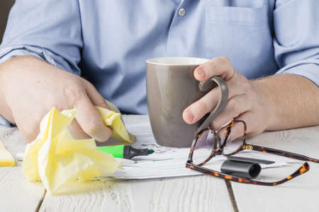 E-learning, online education. Student writing content on paper notebook with a pen while studying online course via laptop computer on wooden desk. Business man planning work on notepad in officeの写真素材
