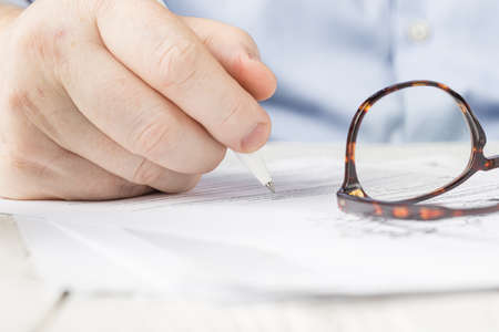 Hand with a pen in a note and table background in seminarsの写真素材