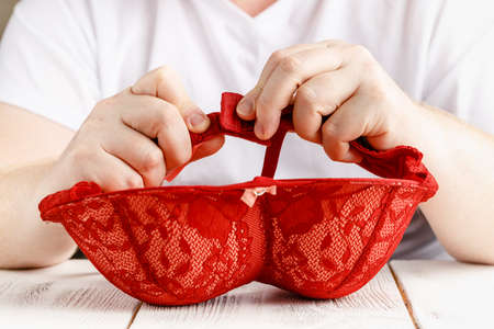 Red sexy lace bra in hands
