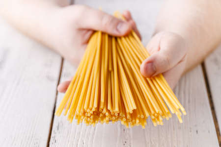 Hand full of raw dry spaghetti, close up view
