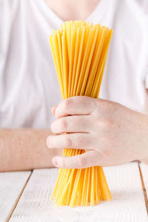 Hand full of raw dry spaghetti, close up view
