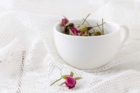 Flower tea rose buds on old wooden tableの写真素材