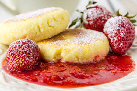 cheese pancakes with berries and powdered sugar, flowers, healthy breakfastの写真素材