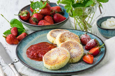 cheese pancakes with berries and powdered sugar, flowers, healthy breakfastの写真素材