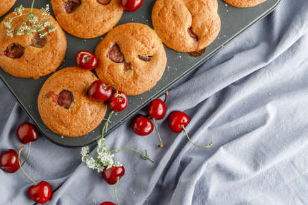 Newly baked  cherry muffin on a muffin trayの写真素材