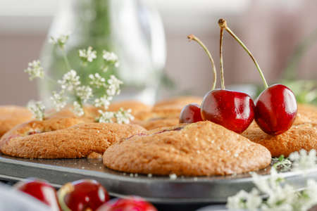 Freshly baked cherry muffins with fresh berries on a rustic wooden tableの写真素材