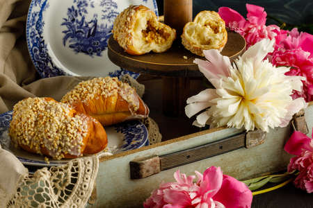 Breakfast with croissants, leaves, flowers composition with retro plates on wooden backgroundの写真素材