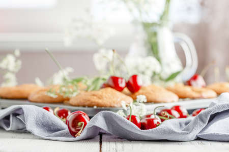 Homemade baking. Cupcakes with cherries.Dessert decorates with fresh berries and leaves. Wooden background. Food stylingの写真素材